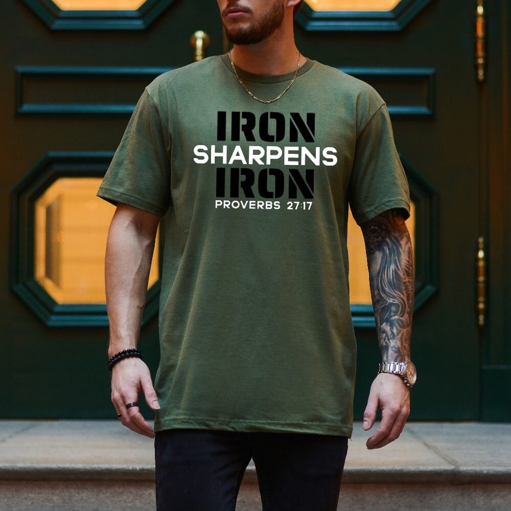 Unisex Iron Sharpens Iron T-shirt miltary green color. "Iron Sharpens Iron Proverbs 27:17" design printed on front in white and black.