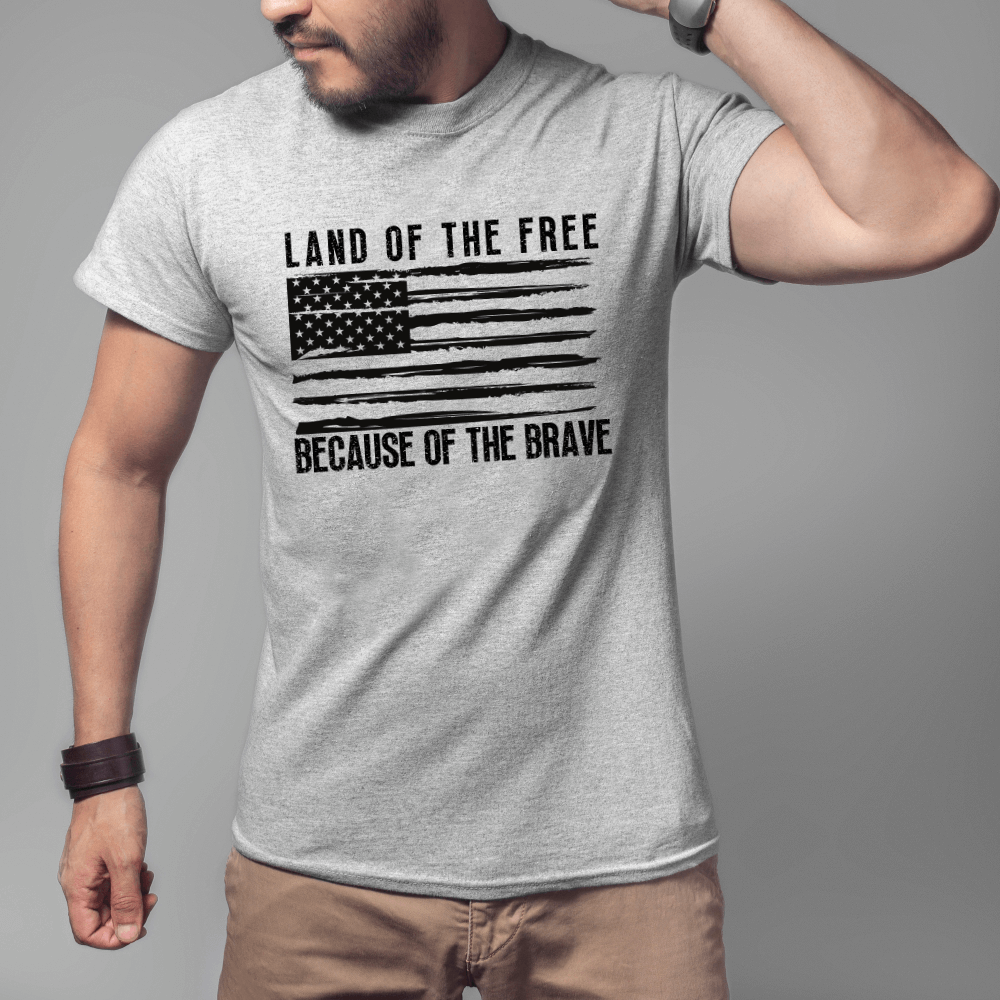 Land of the Free t-shirt, short sleeve sport grey. American flag printed in black on front chest with 'Land of the Free, Because of the Brave" written above and below the flag.  American flag is also printed on the left sleeve.