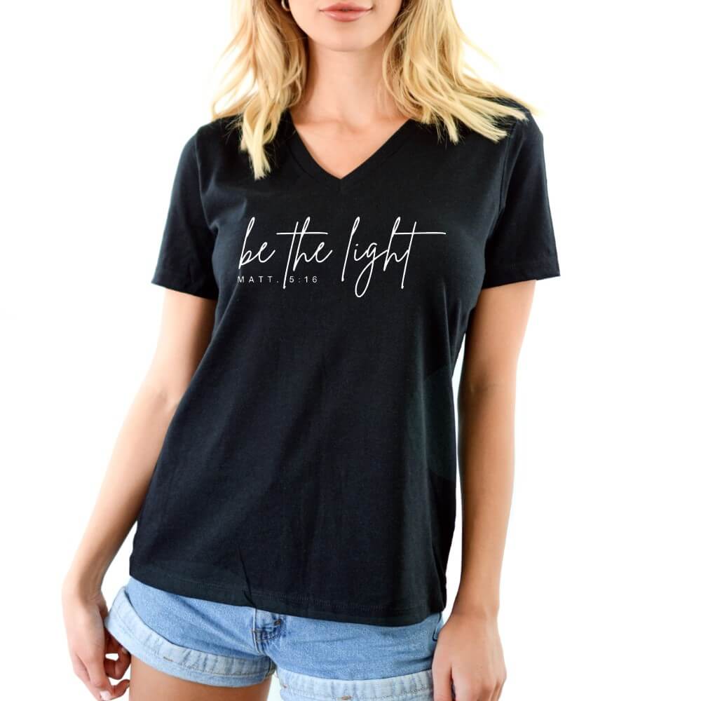 Be The Light women&#39;s V-neck t-shirt black short sleeve.   &quot;be the light - Matt. 5:16&quot; printed in white on front chest. 