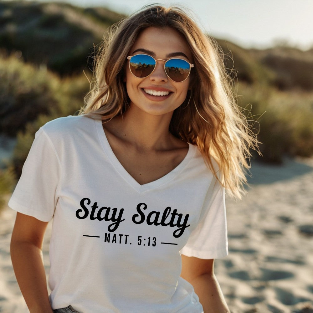 Stay Salty v-neck t-shirt white, short sleeve. On the front chest is printed &quot;Stay Salty - Matt. 5:13&quot; in black font. 