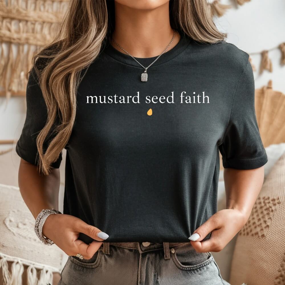 short sleeve unisex t-shirt dark grey with &quot;mustard seed faith&#39; printed on the front chest in white font and a mustard color seed below it. 